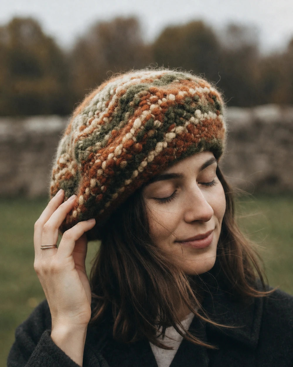 Woman wearing a multicolour hand-knit beret in soft natural light.