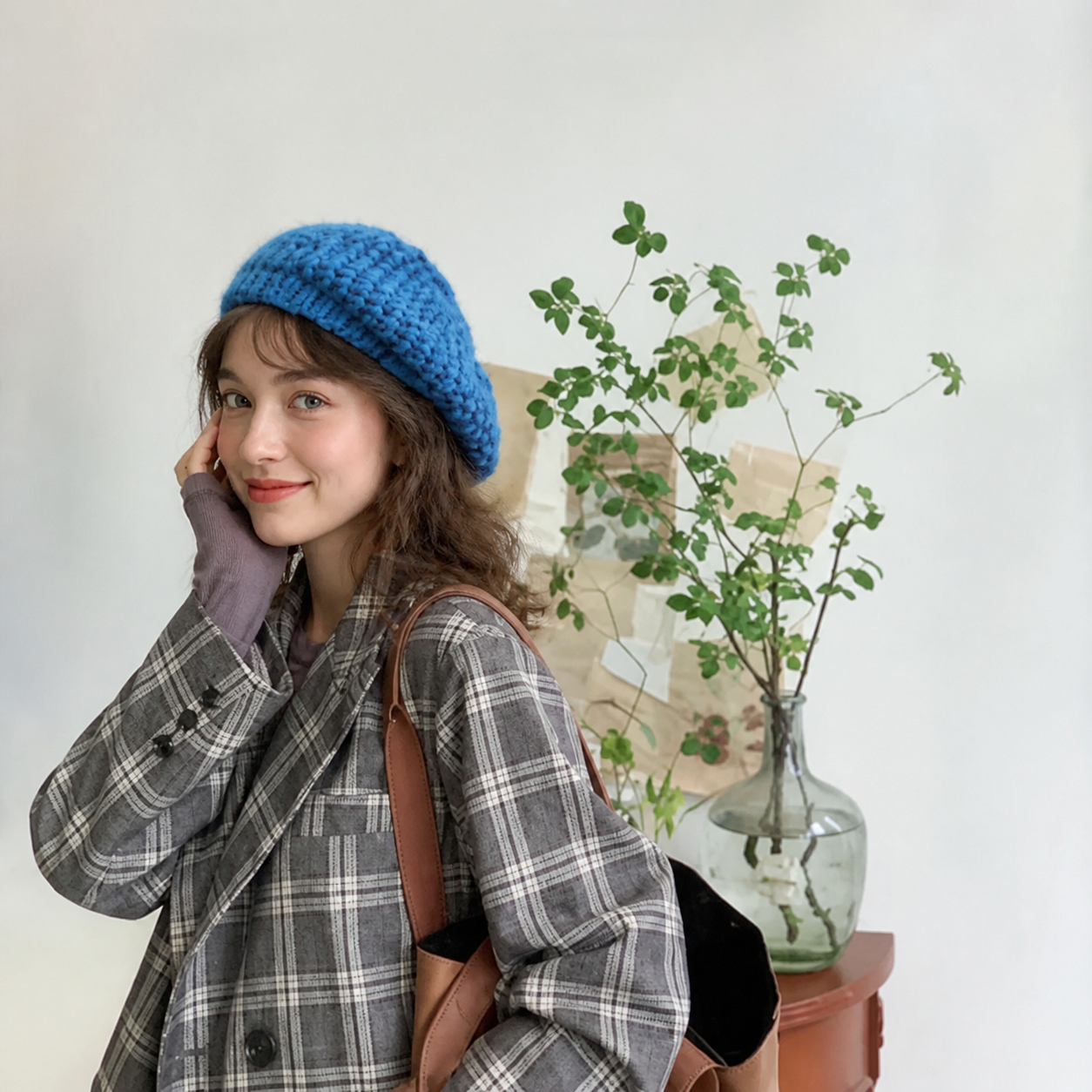 Woman wearing a blue cotton beret with a relaxed side drape