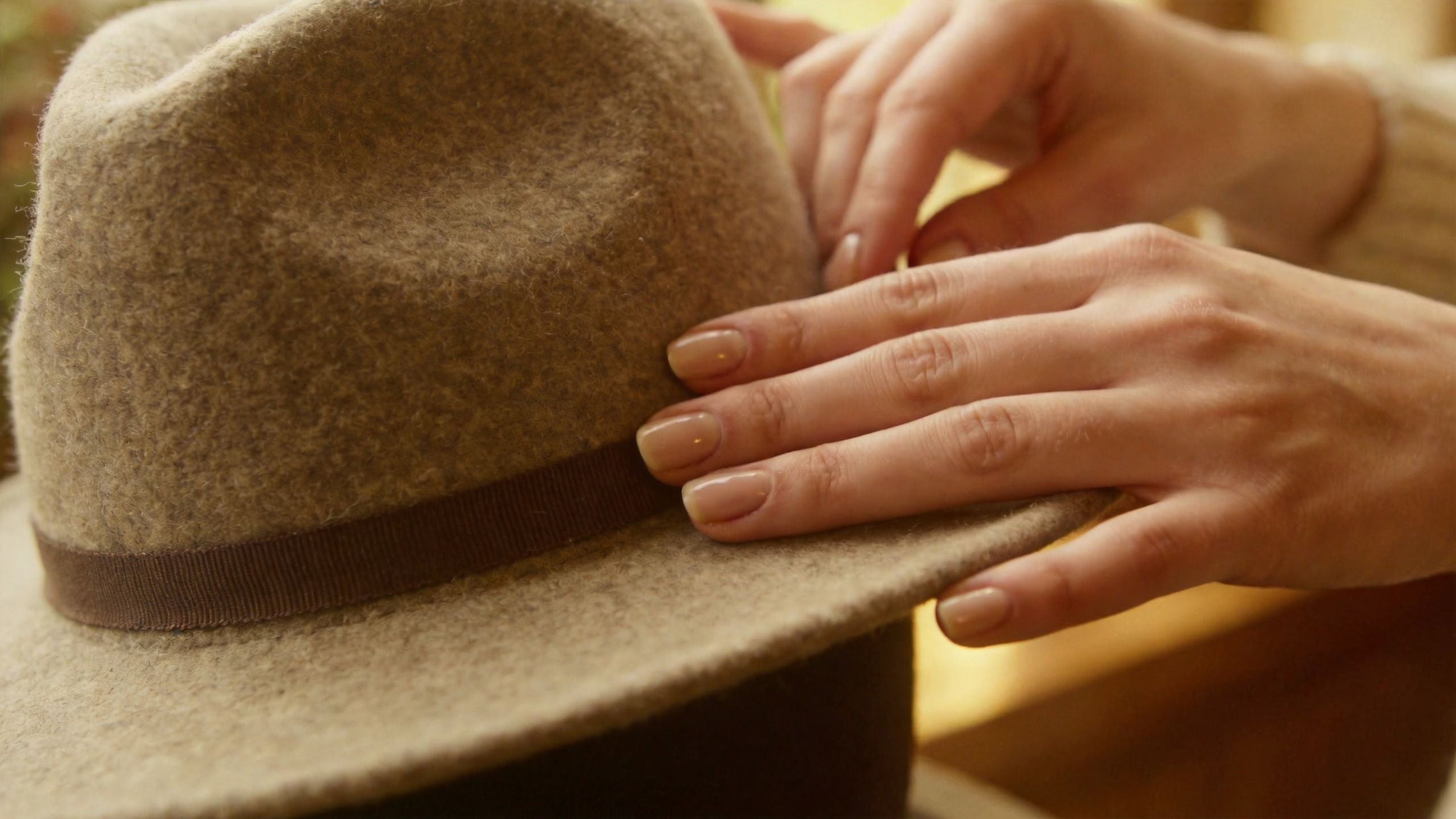 Hands shaping a wool felt hat, introducing a guide to choosing hat materials