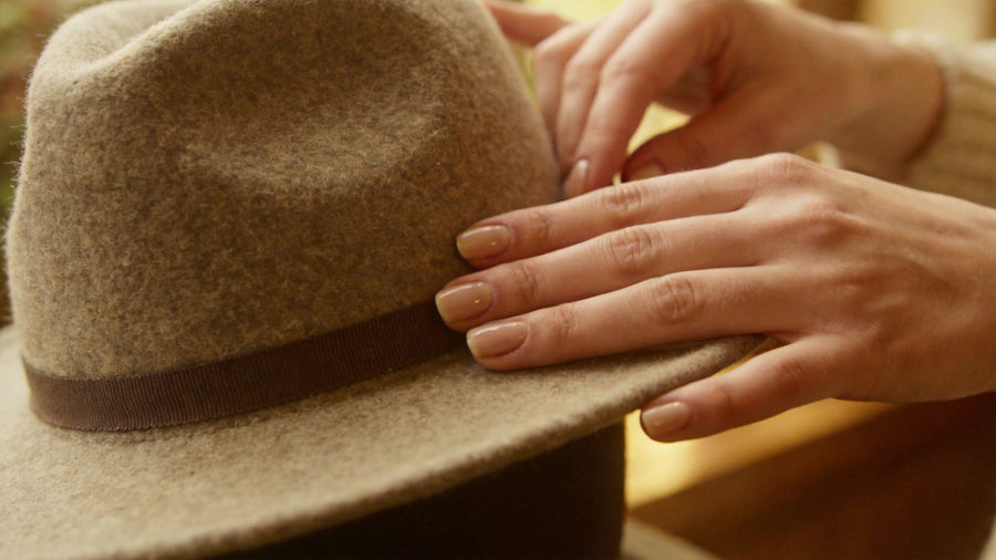 Hands shaping a wool felt hat, introducing a guide to choosing hat materials