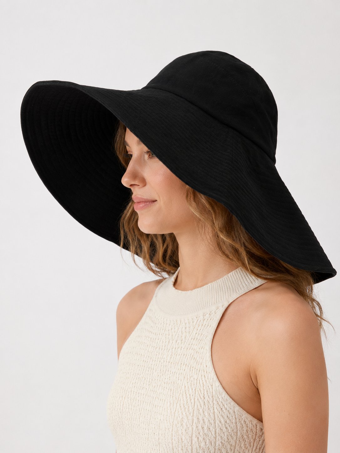 Woman wearing oversized black wide-brim cotton sun hat