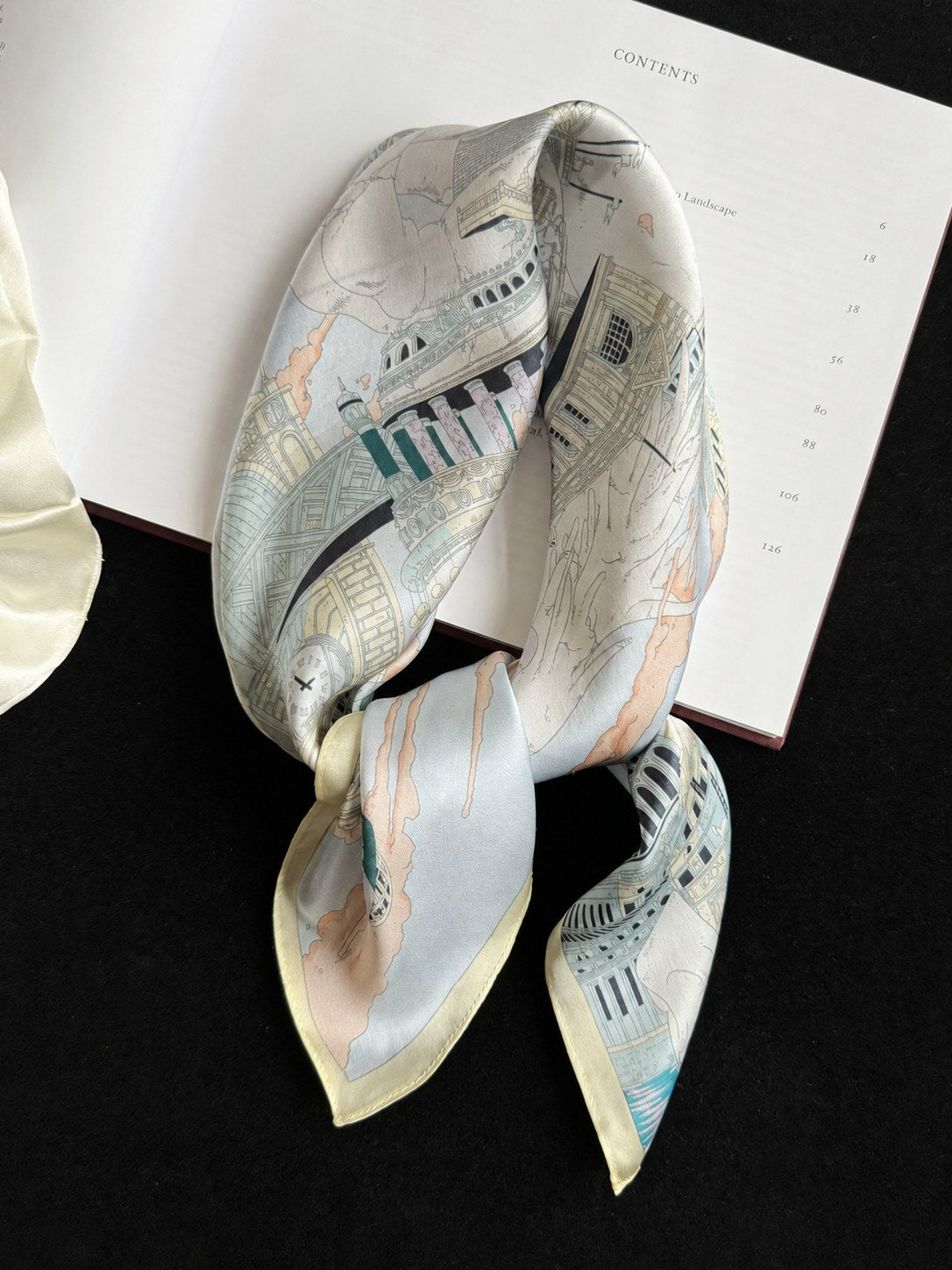 Butter Yellow 65cm mulberry silk square scarf with architectural print styled on a book