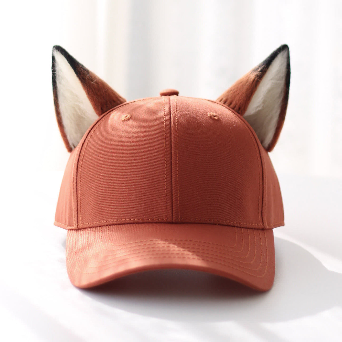 Rust-orange baseball cap with hand-sewn felt fox ears, front view