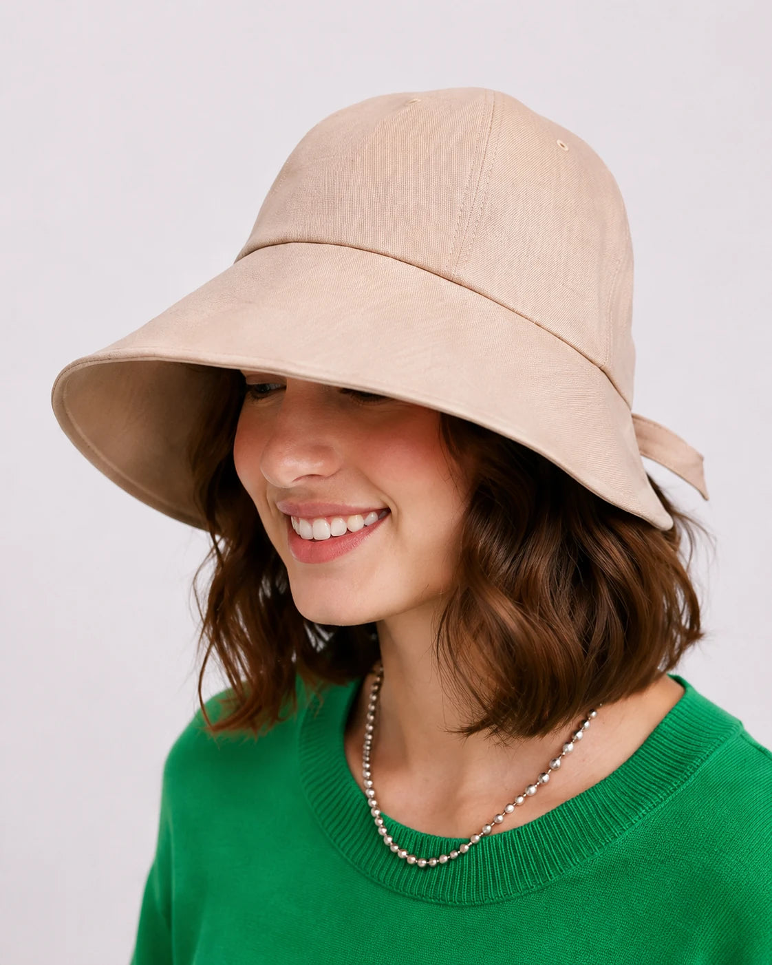 Woman wearing khaki linen wide brim sun hat, front view