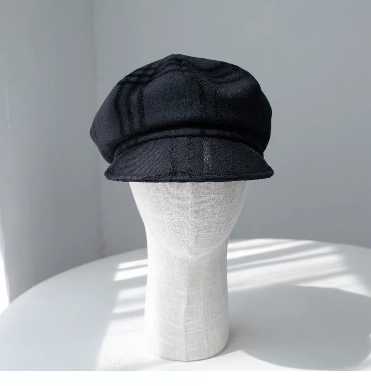 Black fine woven wool newsboy cap shown from the front