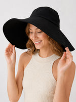 Model in black 15cm wide-brim cotton sun hat, angled view