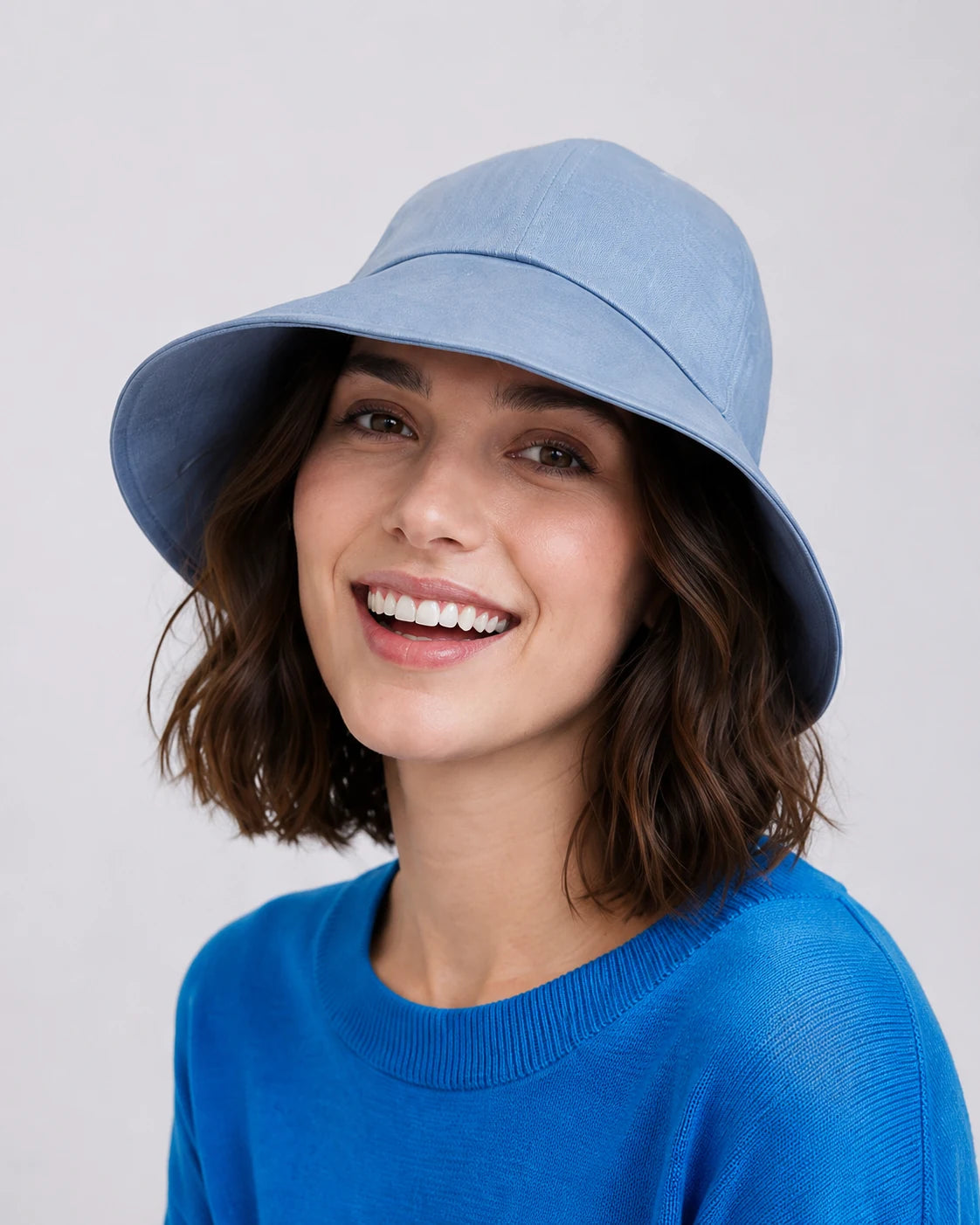 Woman wearing light blue linen wide brim sun hat, front view