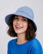 Woman wearing light blue linen wide brim sun hat, front view