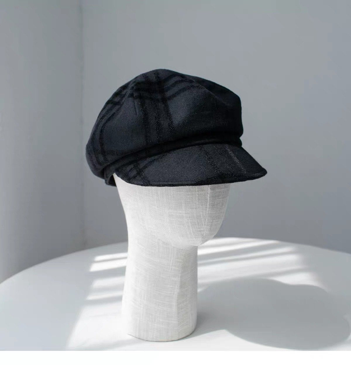 Black fine woven wool newsboy cap shown from the left front