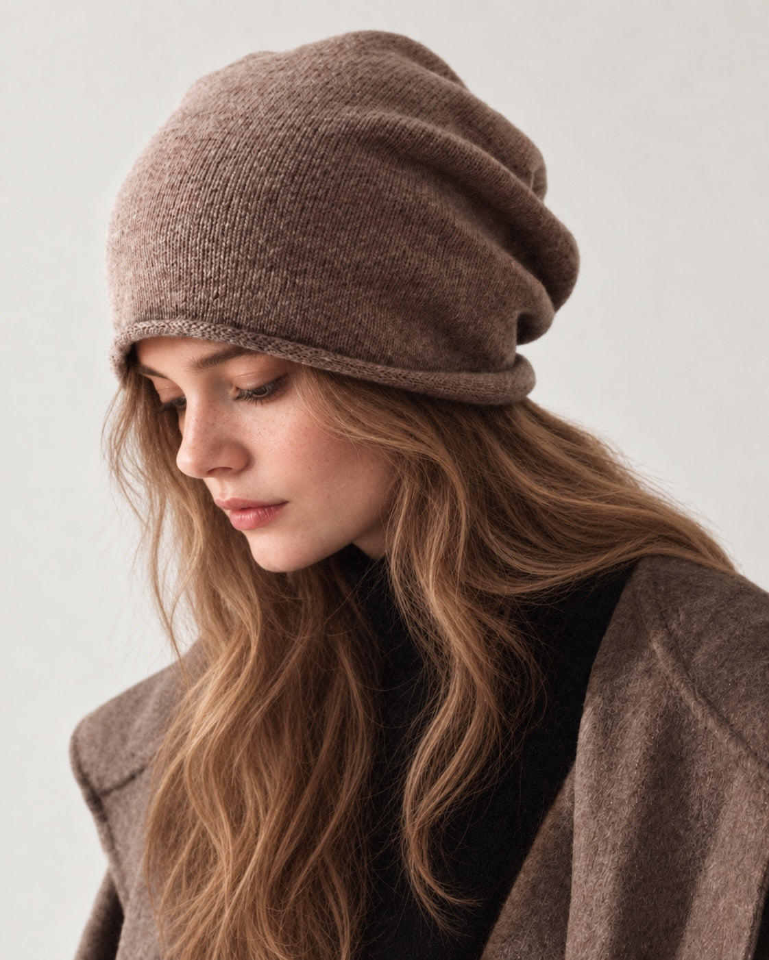 Camel wool slouchy beanie on a woman looking downward