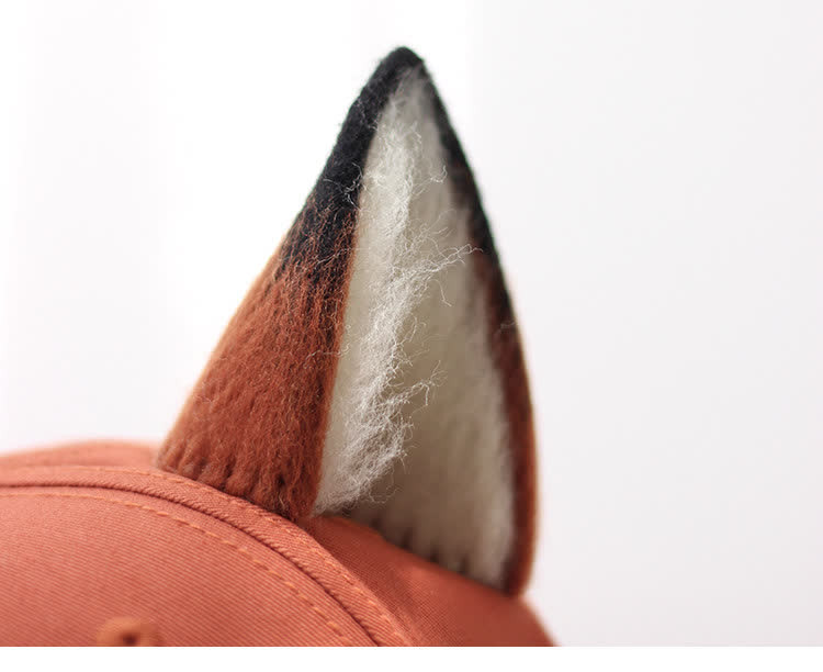 Close-up of a hand-sewn felt fox ear with brown, cream and black shading