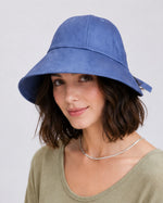 Woman wearing dark blue linen wide brim sun hat, front view