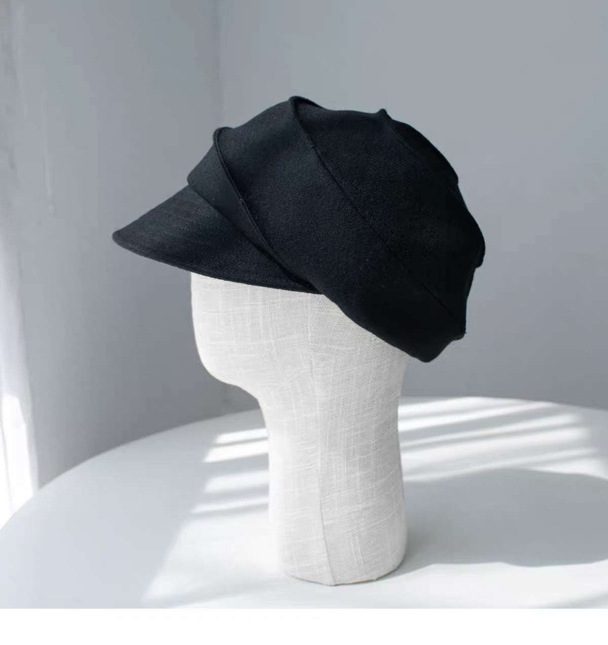 Black sculpted wool newsboy cap shown from the left side