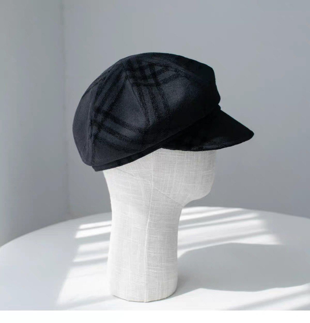 Black fine woven wool newsboy cap shown from the right front