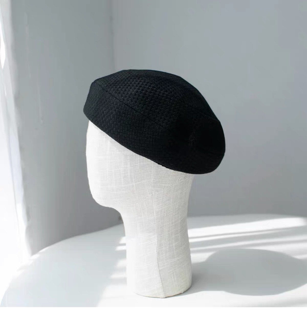 Black structured wool beret shown from the left side