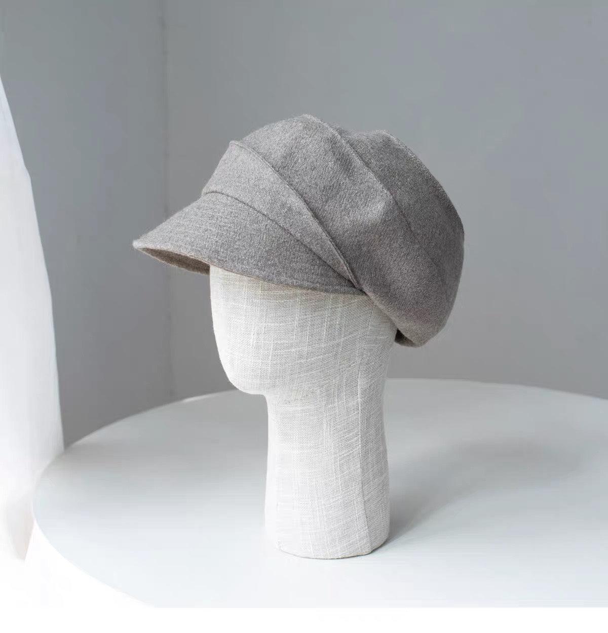 Beige sculpted wool newsboy cap shown from the left side