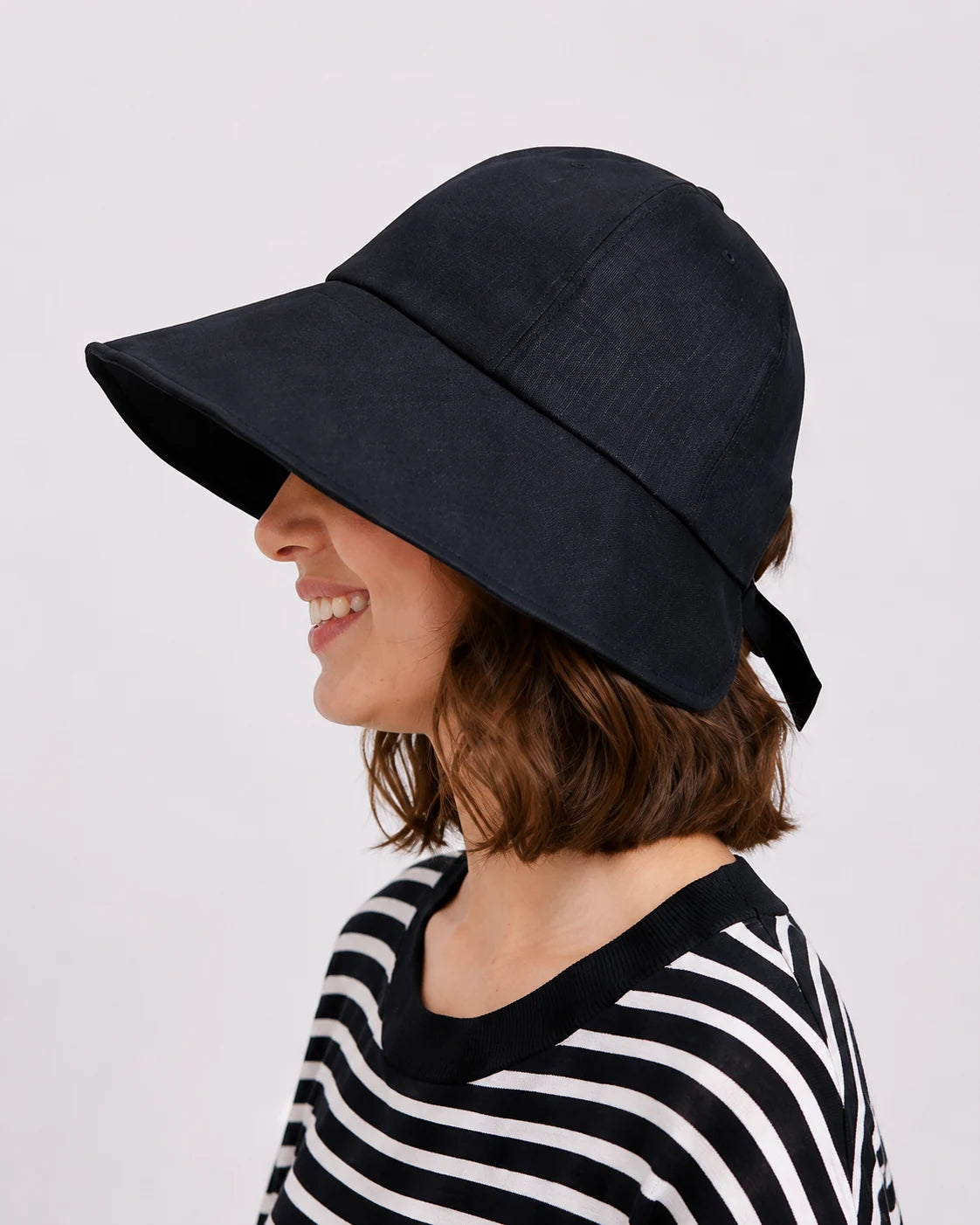 Side profile of woman in wide brim linen sun hat