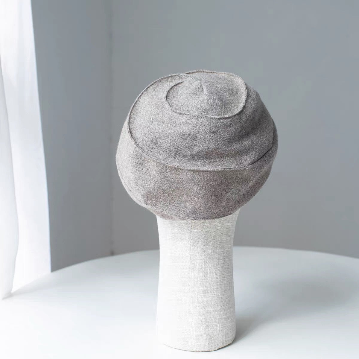 Rear and top view of the beige wool newsboy cap's curved panel construction