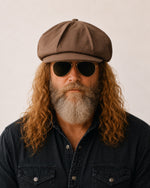 Man wearing brown linen newsboy baker boy cap
