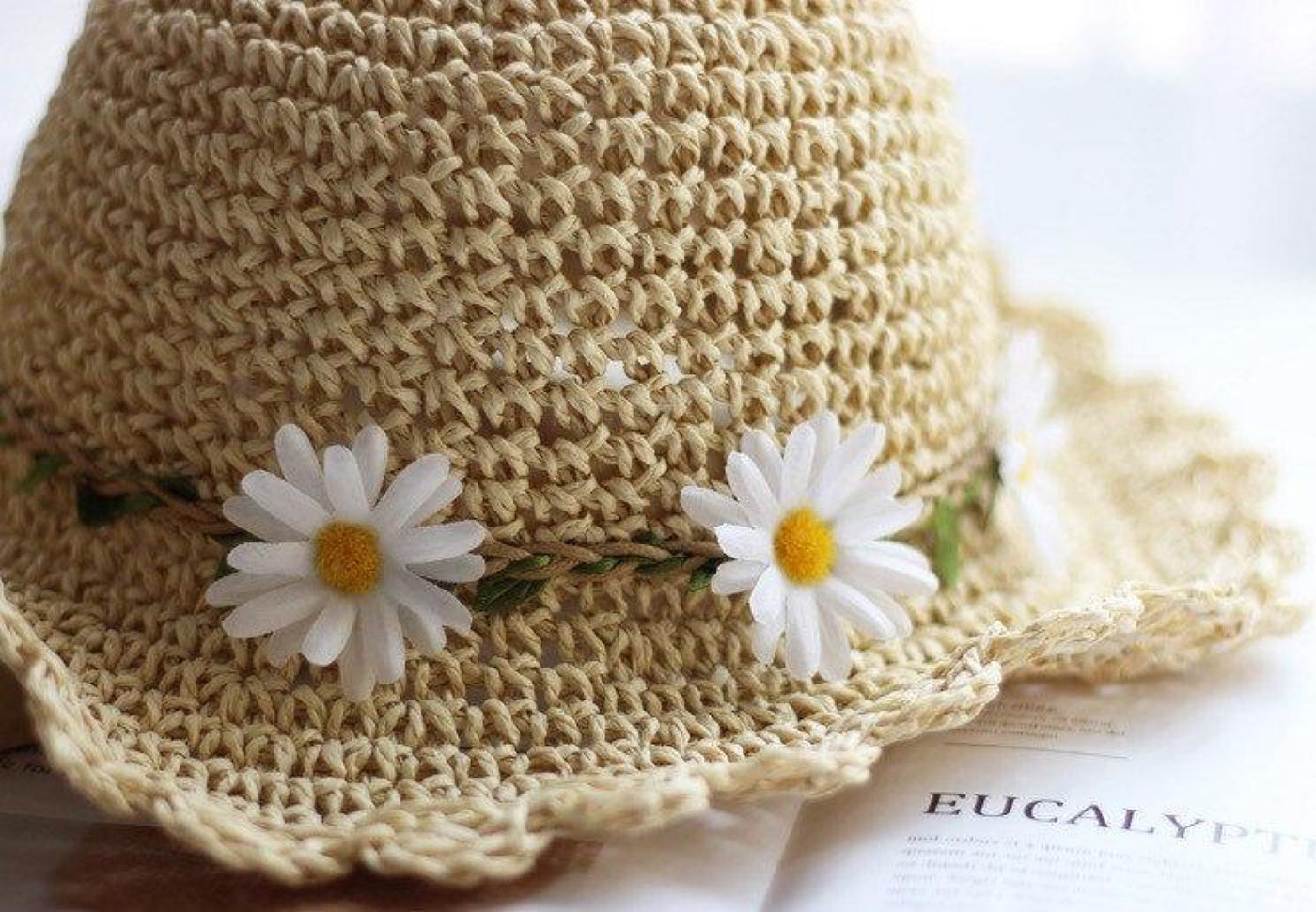 Close-up of White Daisy Garland Detail on Natural Straw Hat Band - Handcrafted Floral Decoration