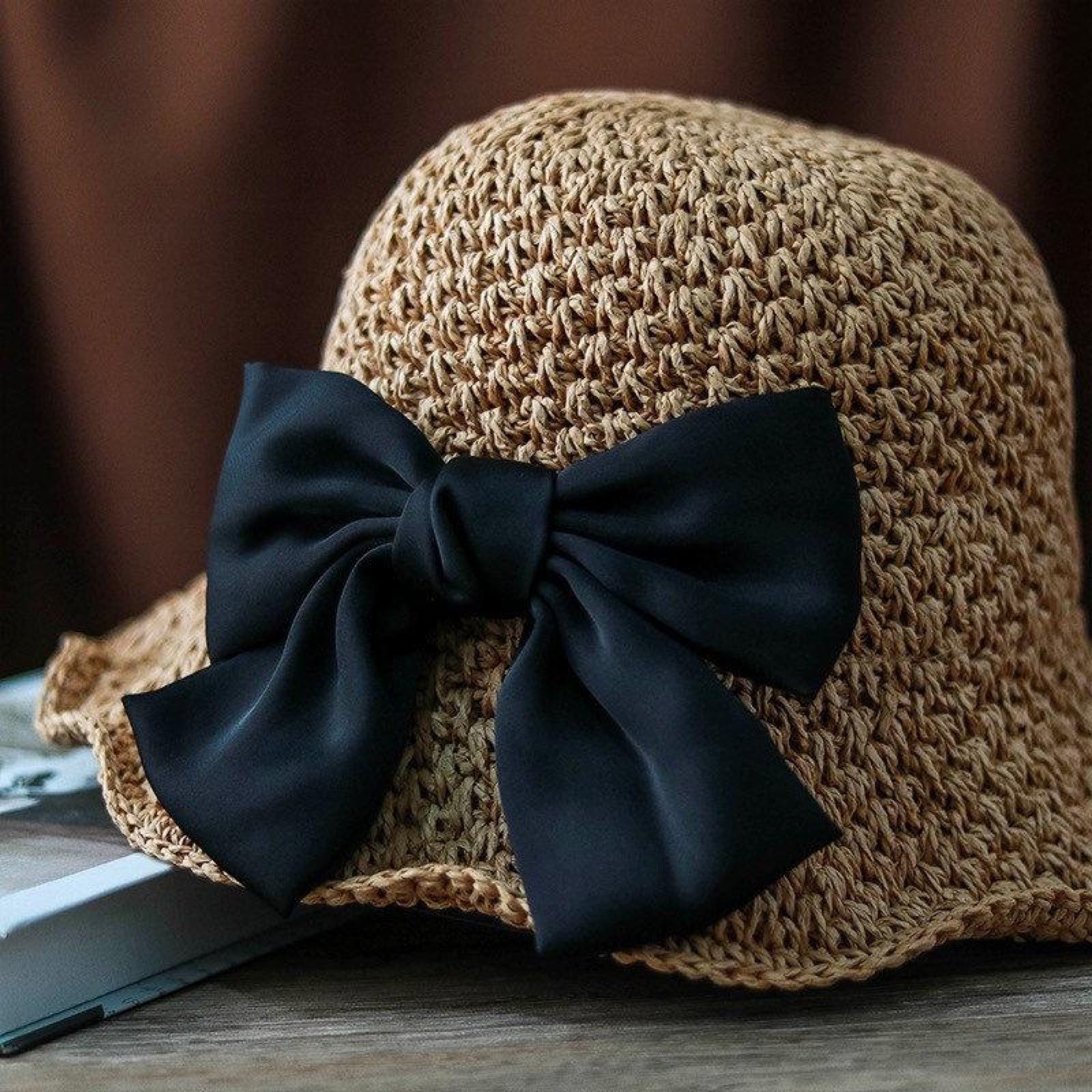 Close-up of camel straw hat with large black bow detail