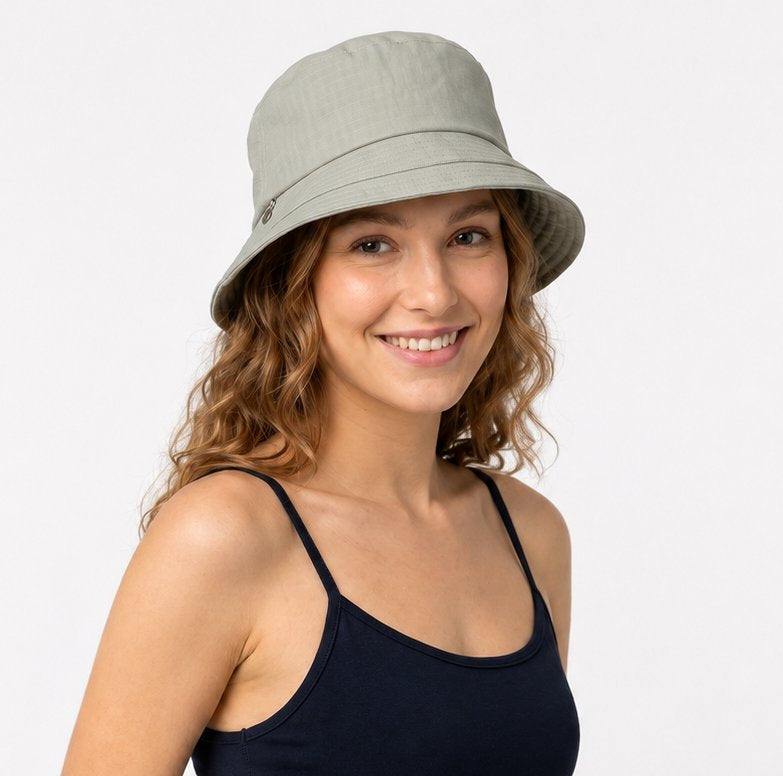 Woman wearing sage green cotton sun hat with navy top, front view