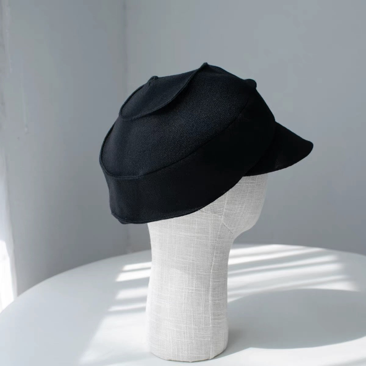 Black sculpted wool newsboy cap shown from the right side