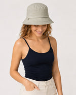 Sage green cotton bucket sun hat on model looking down