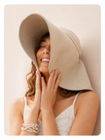 Woman in cream wide-brim sun hat, front view