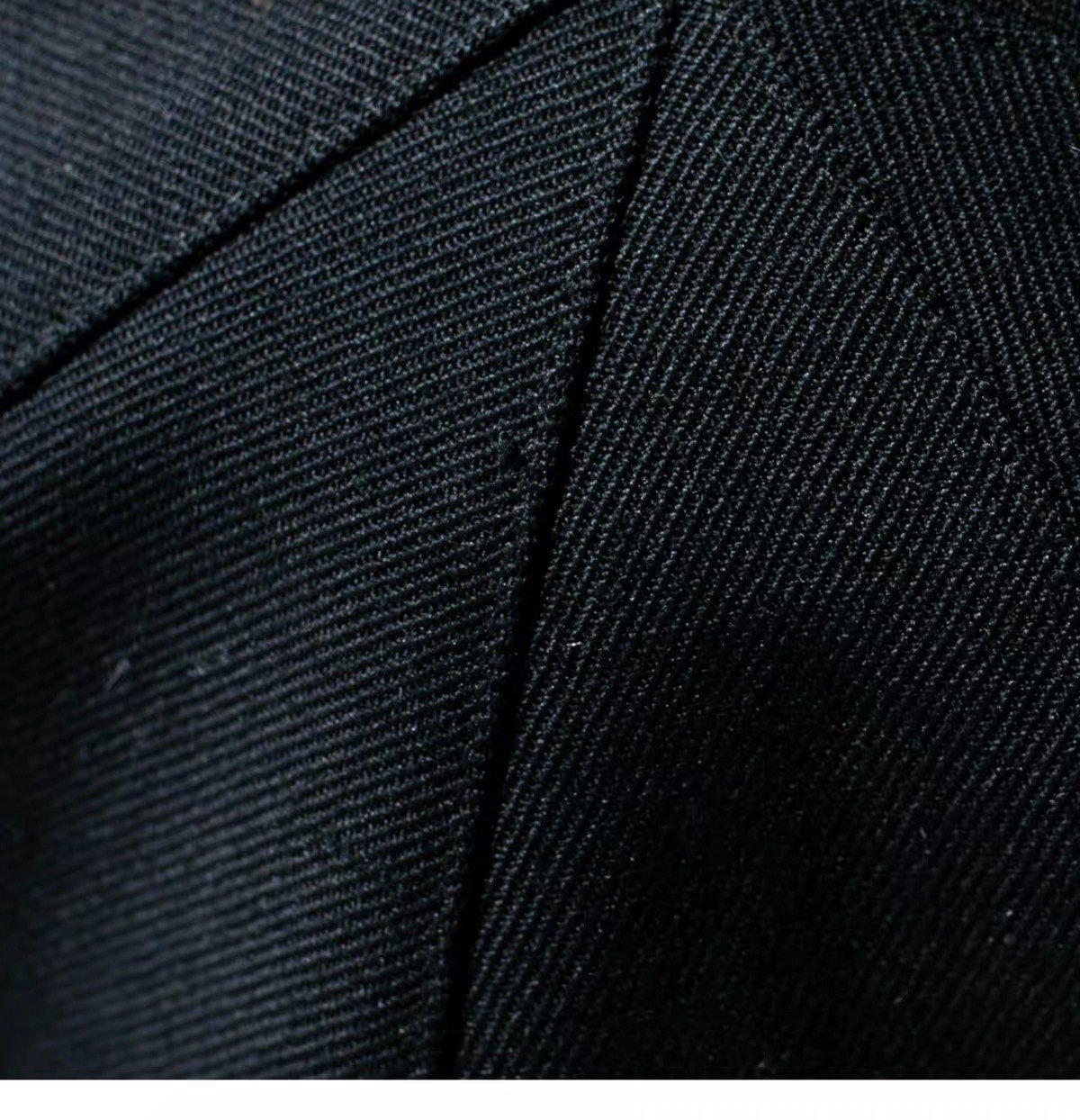 Close view of the black fine woven wool seams and texture