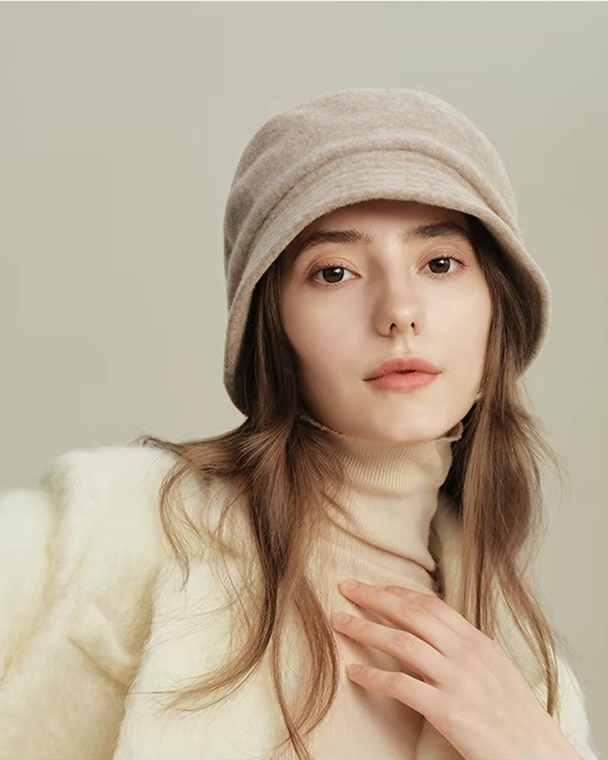 Close-up of a beige 100% wool cloche hat on a female model