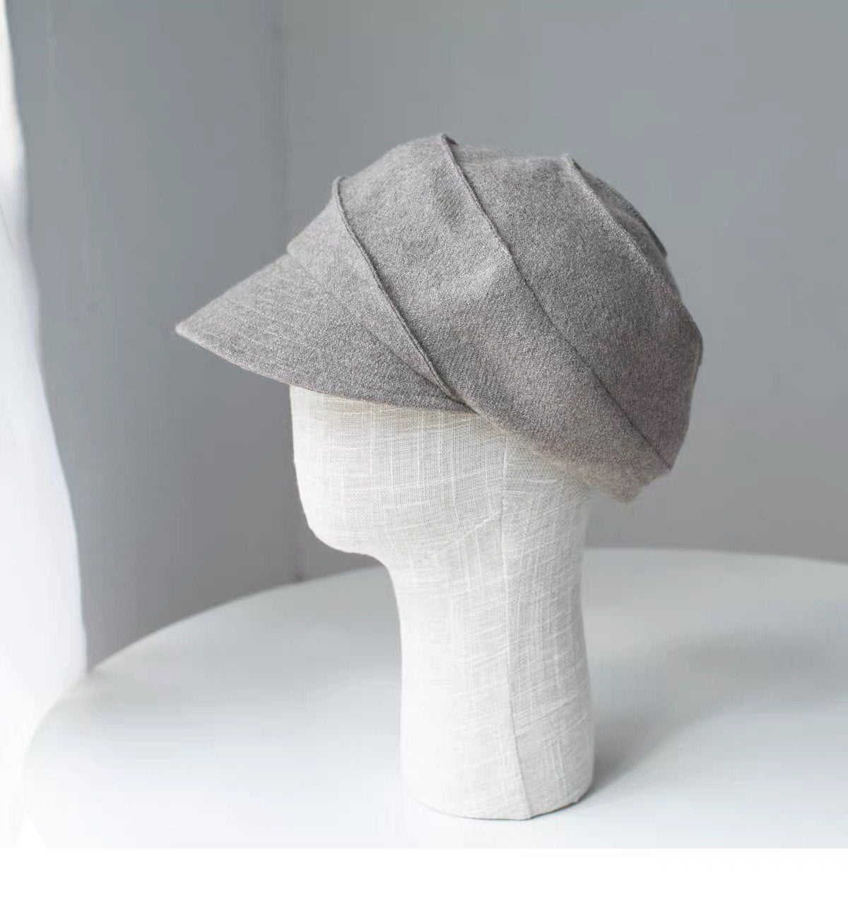 Beige sculpted wool newsboy cap shown from the right side