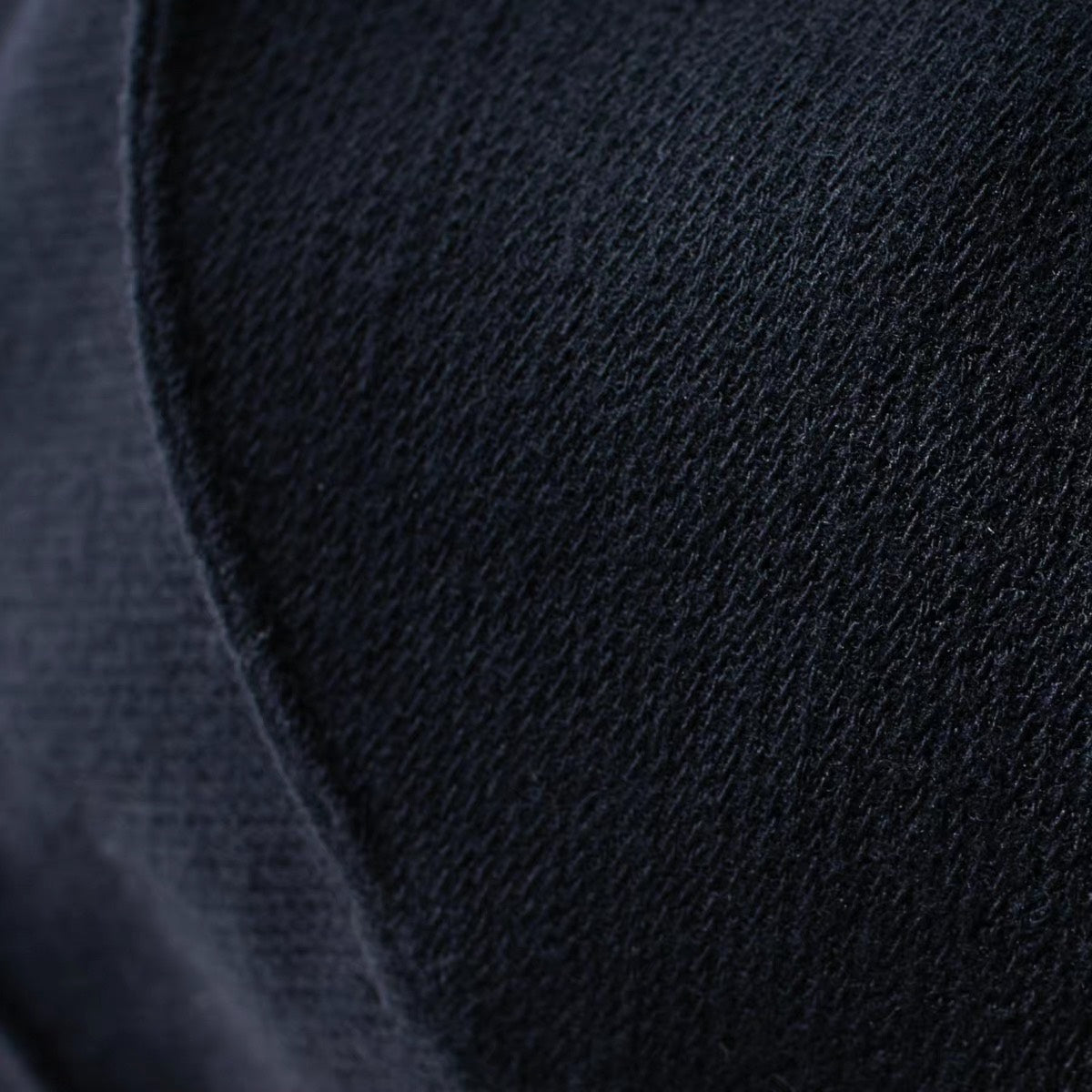 Close view of the navy 100% wool surface and curved seam