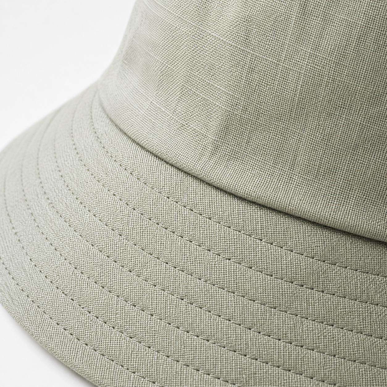 Close-up of sage green cotton sun hat fabric weave and stitching