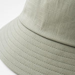 Close-up of sage green cotton sun hat fabric weave and stitching