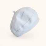 Woman wearing light blue cotton linen French beret