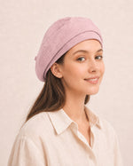 Woman wearing light pink cotton linen French beret