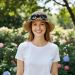 Woman wearing camel straw sun hat with bow, outdoor garden, front view