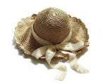 Brown scalloped straw hat with lace bow, top-down view on white background