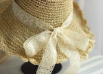 Close-up detail of scalloped straw hat brim and lace bow decoration