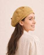 Woman wearing yellow cotton linen French beret