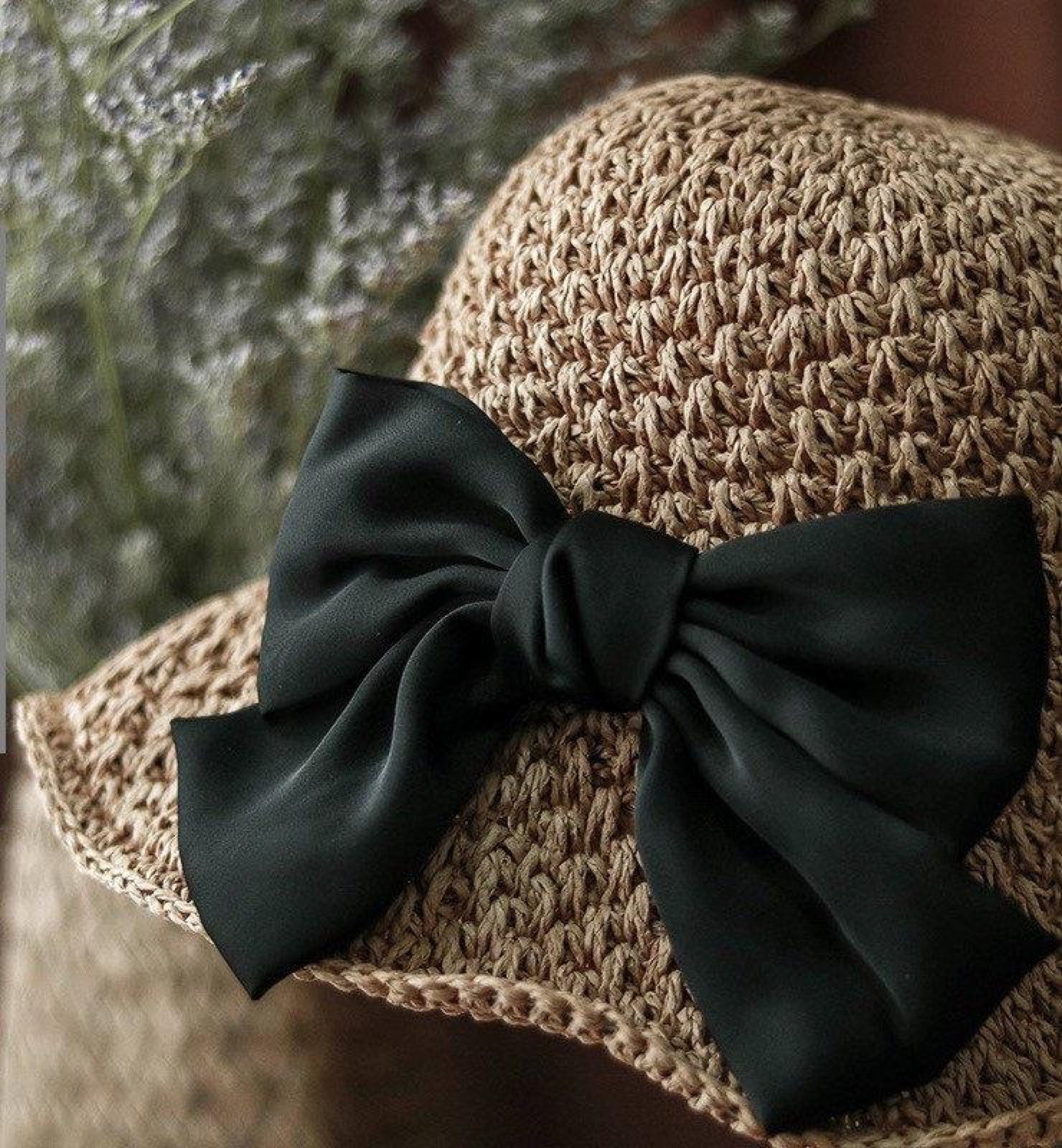 Close-up detail of satin bow on camel straw hat