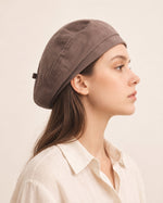 Woman wearing taupe cotton linen French beret
