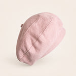 Woman wearing light pink cotton linen French beret