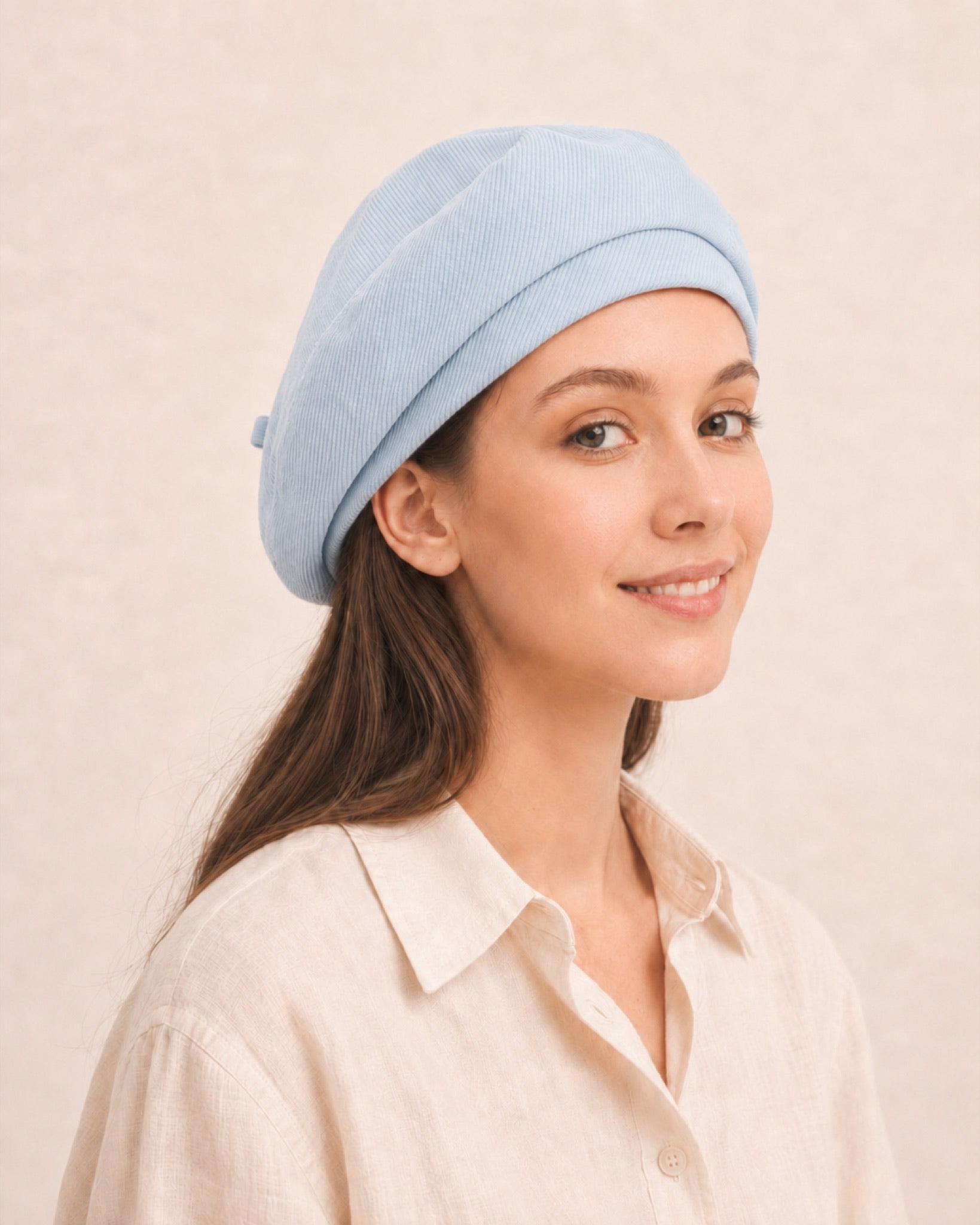 Woman wearing light blue cotton linen French beret