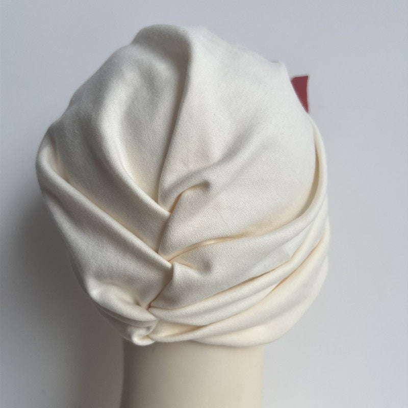 Back view of a beige modal cotton turban hair wrap