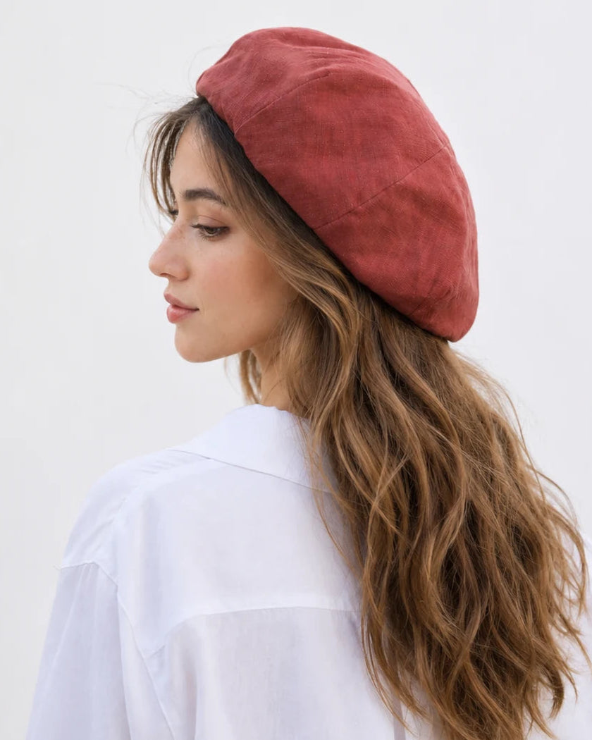 Woman wearing chestnut red linen French beret, back view