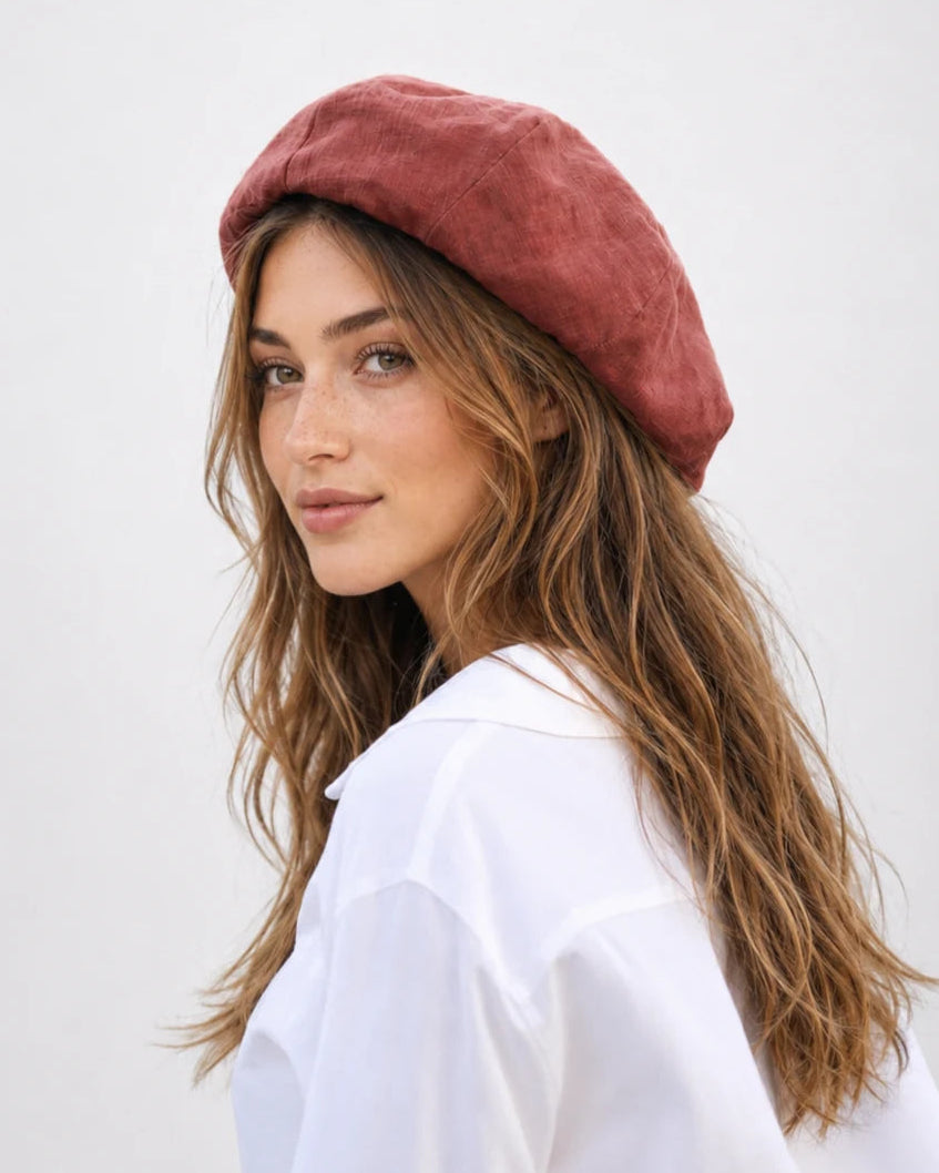 Woman wearing chestnut red linen French beret, side view