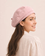 Woman wearing light pink cotton linen French beret