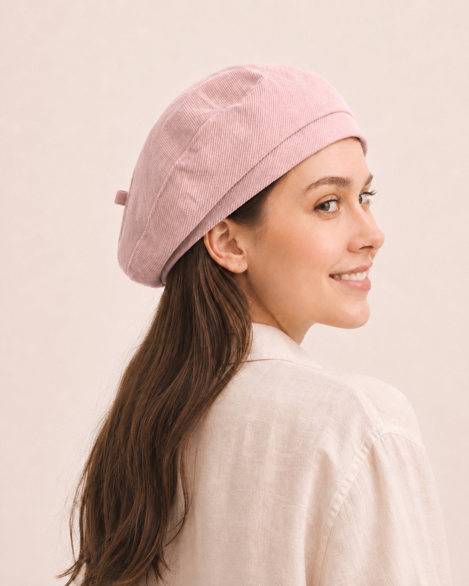 Woman wearing light pink cotton linen French beret